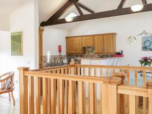 コッカーマスにあるSkiddawの木製のキャビネットと木製の階段付きのキッチン