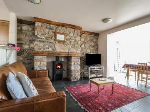 a living room with a couch and a fireplace at Beckside in Cockermouth