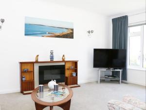 a living room with a television and a table at Sengador in Christchurch