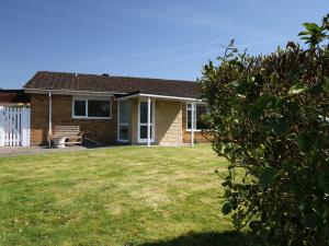a brick house with a bench in a yard at Sengador in Christchurch
