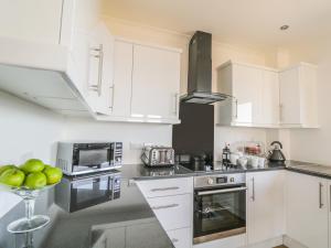 a kitchen with white cabinets and a bowl of apples on the counter at 24 Waters Edge in Banff