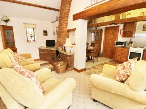 a living room with two couches and a kitchen at Meadow Cottage in Great Edston