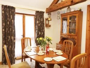 a dining room with a wooden table and chairs at Meadow Cottage in Great Edston