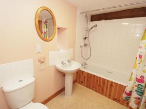 a bathroom with a toilet and a sink and a tub at Sunset Cottage in Great Edston