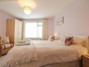 a bedroom with a large bed and a window at Peonies in Exmouth