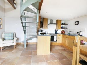 una cocina con armarios de madera y una escalera de caracol en Stone Cross, en Lastingham