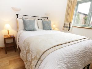 a bedroom with a large white bed with blue pillows at Stone Cross in Lastingham