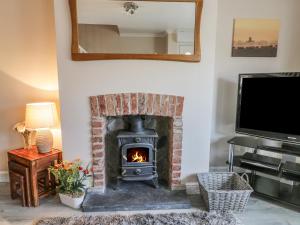 a living room with a fireplace and a television at Bankhouse in Dimlington