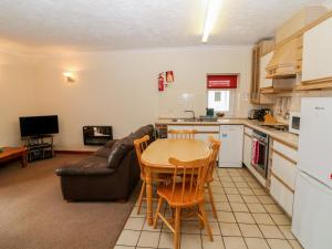 uma cozinha e sala de estar com uma mesa e um sofá em Dinas em Pwllheli