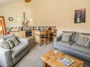 uma sala de estar com dois sofás e uma cozinha em Kitchen Cottage em Sutton