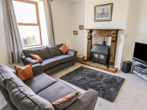 a living room with a couch and a fireplace at Carr House in Balderstone