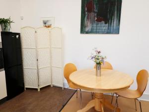 a dining room with a table and chairs and a refrigerator at View The Gallery in Okehampton