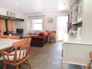una cucina e un soggiorno con tavolo e sedie di Trefollwyn Mawr a Pwllheli
