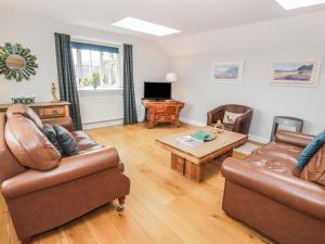 a living room with two couches and a coffee table at Bracken Holiday Cottage in Dalbeattie