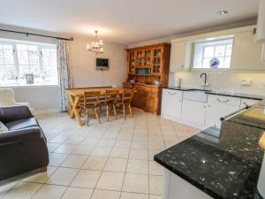 a kitchen and dining room with a table and a couch at Bracken Holiday Cottage in Dalbeattie