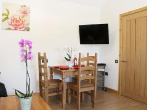 a dining room with a table and chairs and a television at Ramblers in Kerry