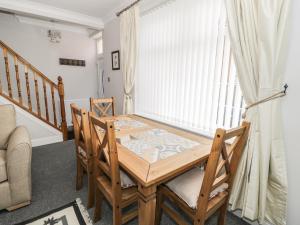 a dining room with a wooden table and chairs at Salee Cottage in Newbiggin-by-the-Sea