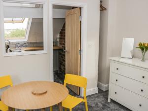 a kitchen and dining room with a table and yellow chairs at The Attic in Keighley