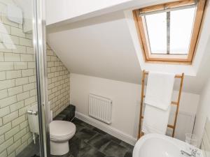 a bathroom with a toilet and a window at The Attic in Keighley