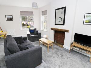 sala de estar con sofá y chimenea en The Flat, en Keighley