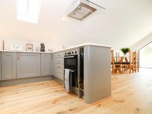 a kitchen with a stainless steel refrigerator and a table at The Hayloft, St Just in St Just