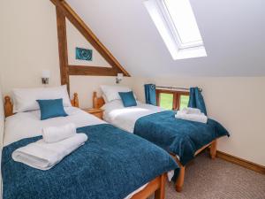 a bedroom with two beds with blue and white sheets at Pentre Fawr in Llanddewi Ystradenny