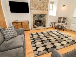 a living room with a couch and a fireplace at Oak Cottage in Barnard Castle