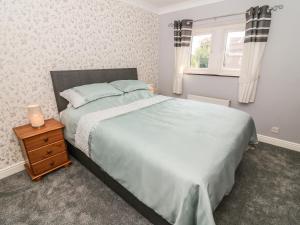sypialnia z dużym łóżkiem i oknem w obiekcie Croft Cottage w mieście Long Preston