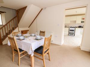 a dining room with a white table and chairs at The Barn in Crickhowell