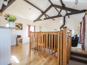 ein Wohnzimmer mit einer Holztreppe in einem Haus in der Unterkunft Esthers Barn in Cockermouth