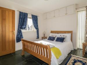 a bedroom with a large bed with blue curtains at Esthers Barn in Cockermouth