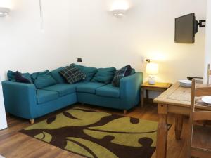 a living room with a blue couch and a table at Woodside Cottage in Kerry