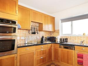 una cocina con armarios de madera y una ventana en Dalnahaven, en Grantown-on-Spey
