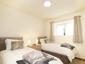 1 dormitorio con 2 camas y ventana en Dalnahaven, en Grantown-on-Spey