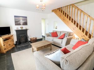 a living room with two couches and a fireplace at Bryn Uchaf in Benllech