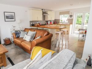 a living room with a couch and a kitchen at 54 The Moorings in Cardigan