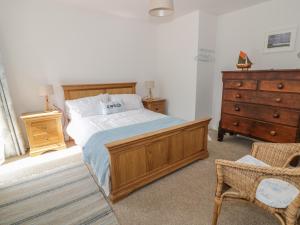 a bedroom with a large bed and a dresser at 54 The Moorings in Cardigan