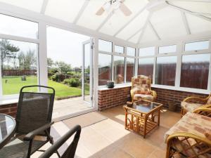 a conservatory with a white conservatory ceiling and windows at Seaspray in Withernsea