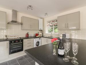 uma cozinha com um balcão com dois copos de vinho em The Hen House em Bromyard
