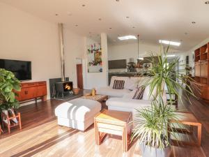 a living room with a white couch and a fireplace at Chy Lagen Hos in Newquay