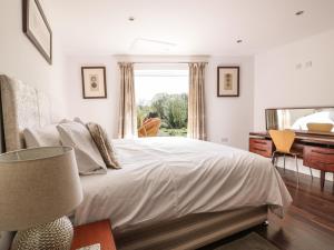 a bedroom with a bed and a desk and a window at Chy Lagen Hos in Newquay