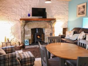 a living room with a table and a fireplace at Mary Larkin's Cottage in Lisnacree