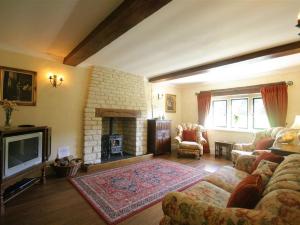 a living room with a couch and a fireplace at Lakeside Cottage in Painswick