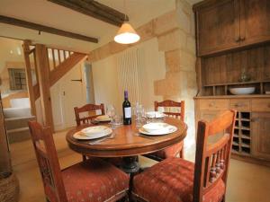 a wooden table with chairs and a bottle of wine at Shepherds Hay in Broadway