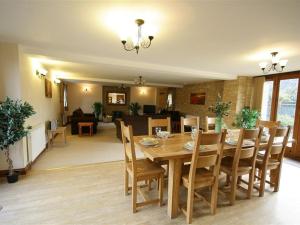 a dining room and living room with a table and chairs at Tithe Barn, Lyneham in Bruern