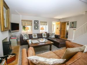 uma sala de estar com um sofá e uma mesa em Fairview Cottage em Burford