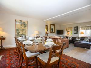 uma sala de jantar com mesa e cadeiras e uma sala de estar em Fairview Cottage em Burford