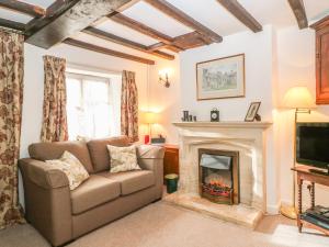 a living room with a couch and a fireplace at Wadham Cottage in Bourton on the Water