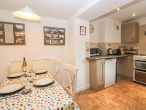 a kitchen and dining room with a table and chairs at Wadham Cottage in Bourton on the Water