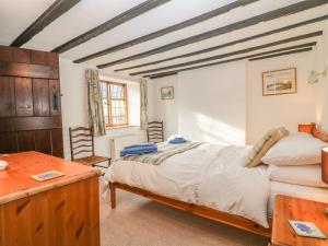 a bedroom with a bed and a table and chairs at Wadham Cottage in Bourton on the Water